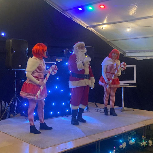 Trumpington Meadows Winter Wonderland: Santa and elves on stage. Photo: TM DAG, 15 December 2023.